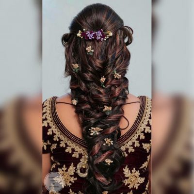 voluminous fishtail braid with floral embellishments