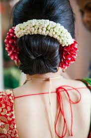 bridal hairstyle bun with red and white flowers