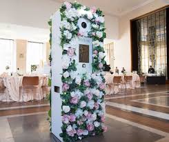 life size photo booth covered with white and pink flowers