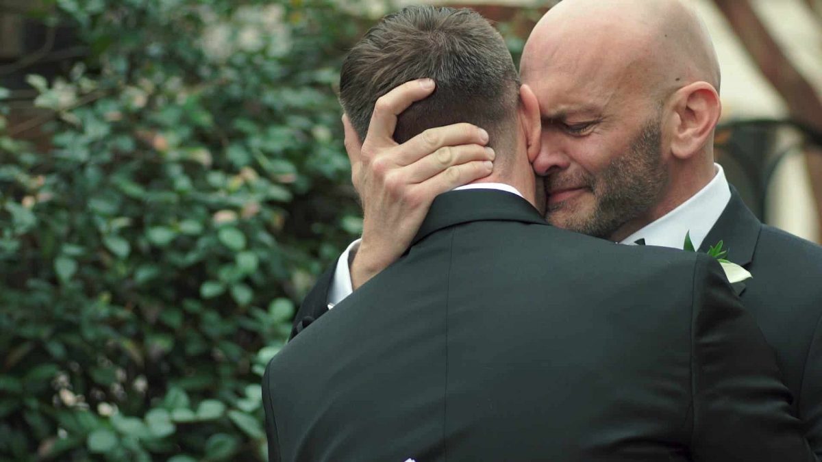 embracing gay wedding shot