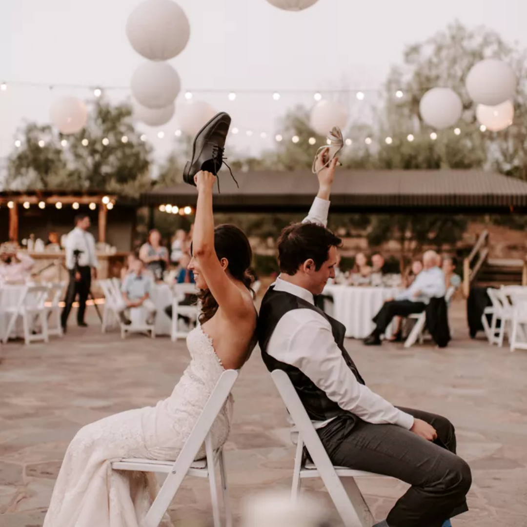 Couple sitting over the chairs to play to play the wedding shoe game.