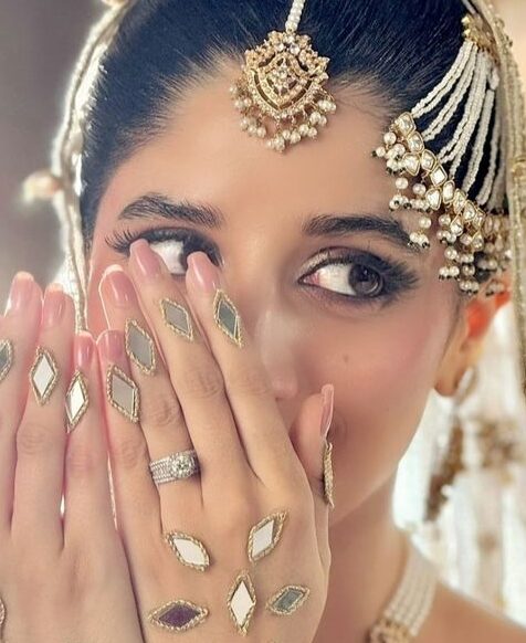 bride showing embellished mehendi with glitter accents