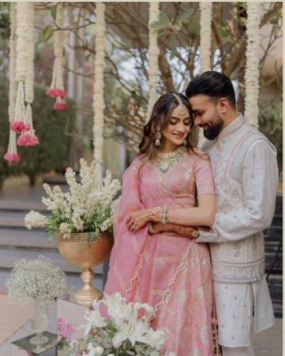 bride and groom matching outfit with pastel lehenga and ivory sherwani