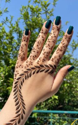 leafy trail mehendi design on backhand with minimal coverage